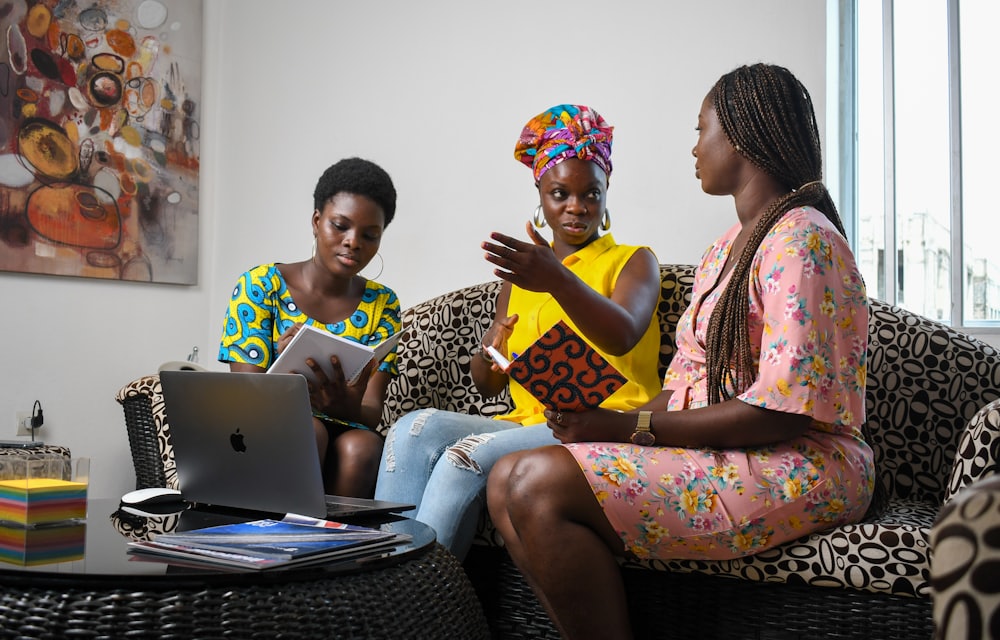 Three colleagues reviewing work together on a laptop in a Lagos office
